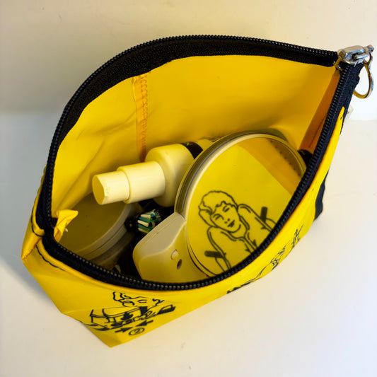 Cosmetics purse from upcycled aircraft life vest, spacious, sturdy and lightweight made from recycled pvc and Kevlar material, featuring rescue safety images, so brace for impact with this unique utility bag for your next flight or holiday!