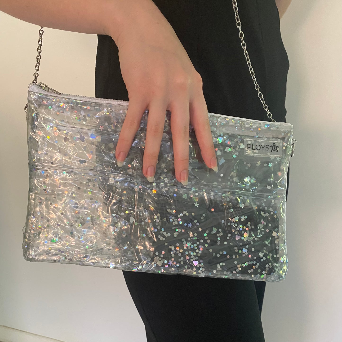 Model showing silver glitter evening purse sustainably made from upcycled pool inflatables