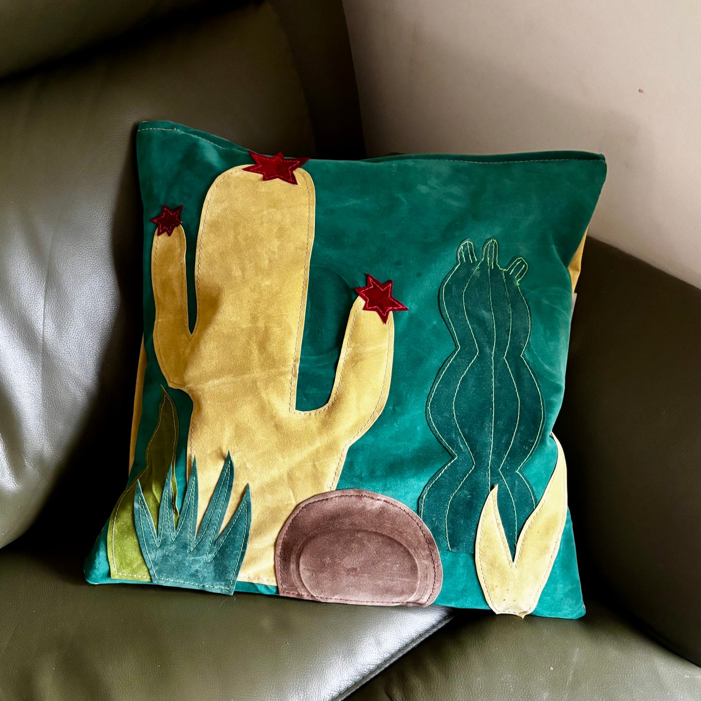Decorative pillow with a cactus design on a couch