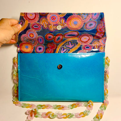 Colourful indigenous patterned clutch with a ocean themed blue base and decorative chain made from upcycled plastic 