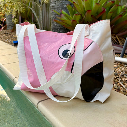A pink and white flamingo-themed waterproof tote swim bag with white shoulder straps,ade from upcycled pool inflatables 