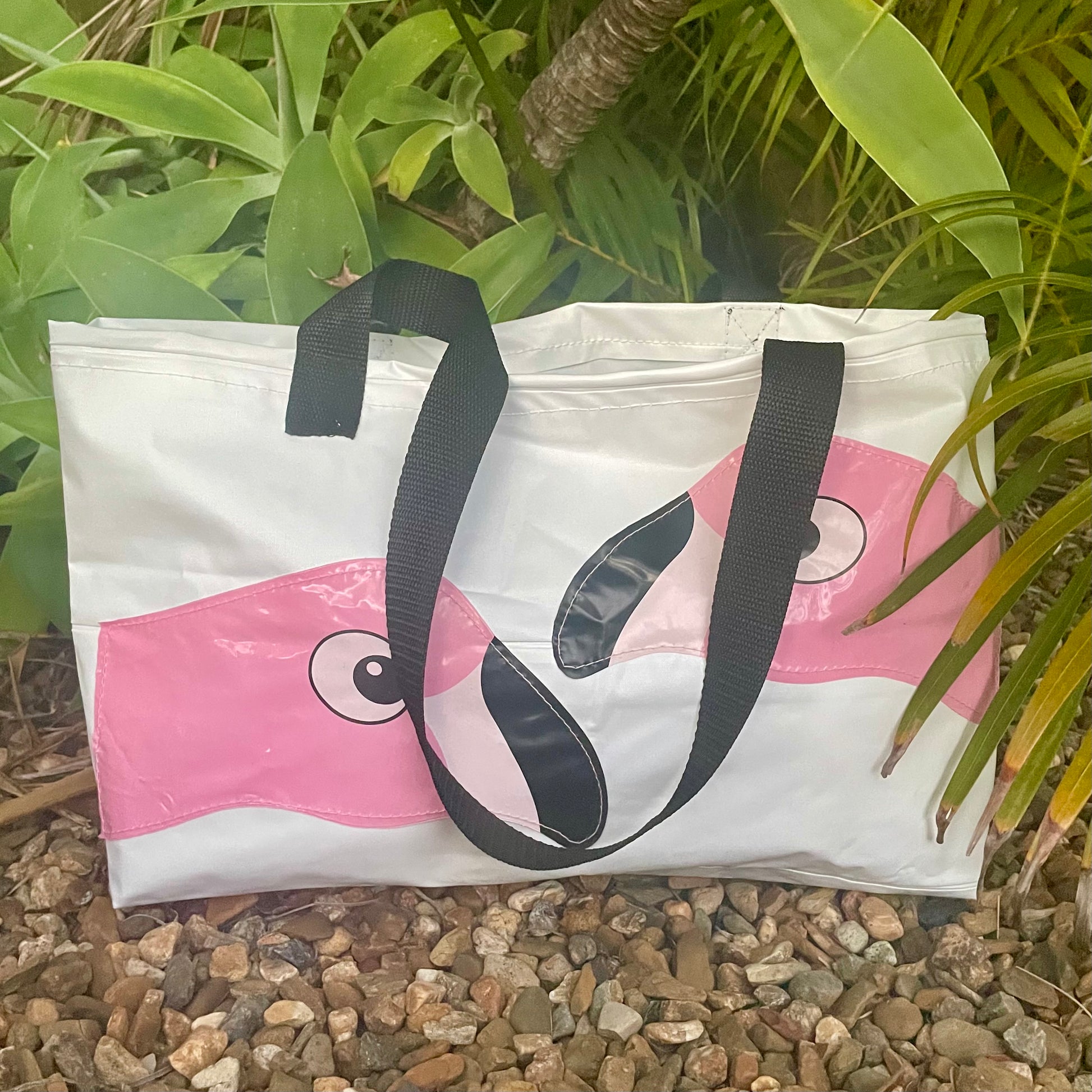 White beach bag made from upcycled pvc with flamingo design on a natural background