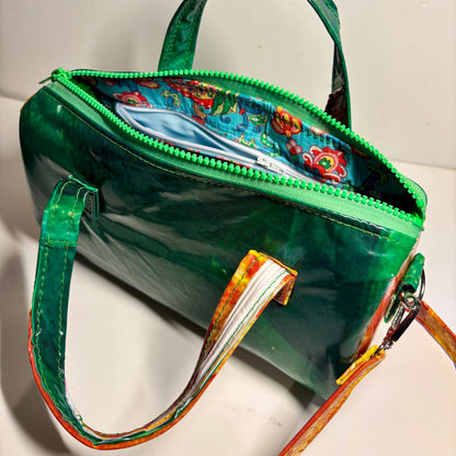 Dark green and orange oval shaped PVC handbag with strap in contrasting colours made from upcycled pool inflatables 