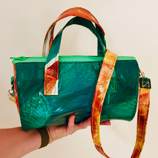 Dark green and orange oval shaped handbag with strap in contrasting colours made from upcycled pool inflatables 