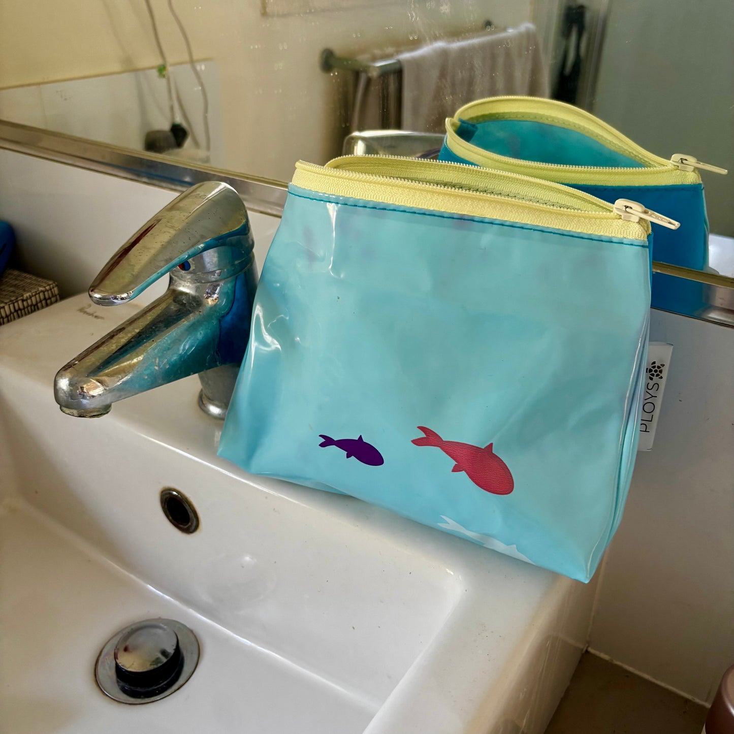 Upcycled cosmetics purse handmade from repurposed pool inflatables using recycled PVC plastic.